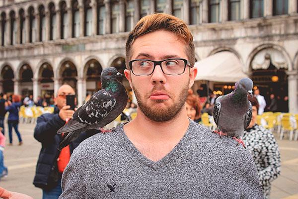 Man with two pigeons on his shoulders.